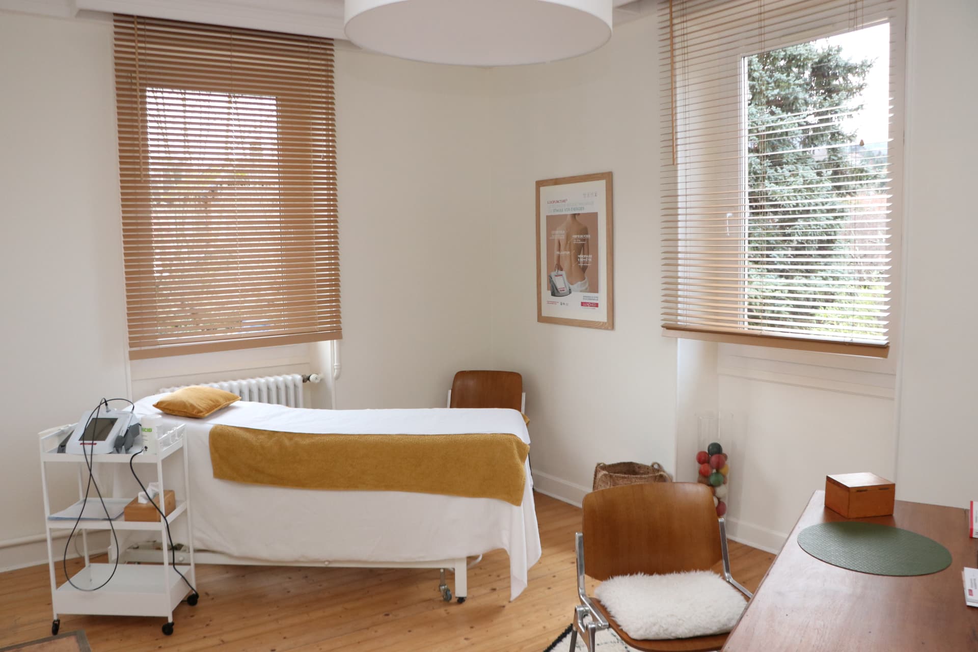 Salle de soin du cabinet de Luxopuncture® à Chambéry : table de massage et appareil Luxoscreen